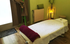 Massageraum mit einer Liege in gemütlicher Atmosphäre