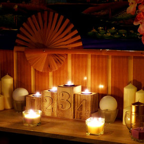 Auf einem Tisch sind brennende Kerzen und Blumen platziert